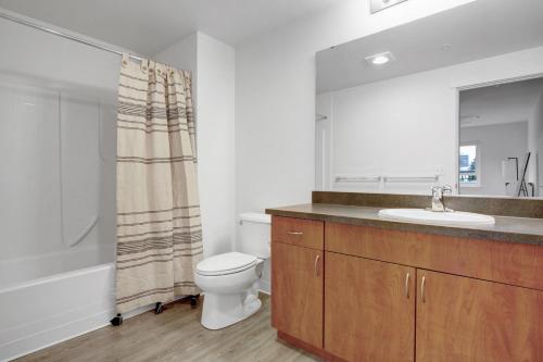 a bathroom with a toilet and a sink and a mirror at Downtown Bellevue 2BR w WD Storage nr Shops SEA-222 in Bellevue