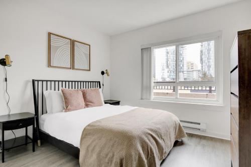 a white bedroom with a bed and a window at Downtown Bellevue 2BR w WD Storage nr Shops SEA-222 in Bellevue