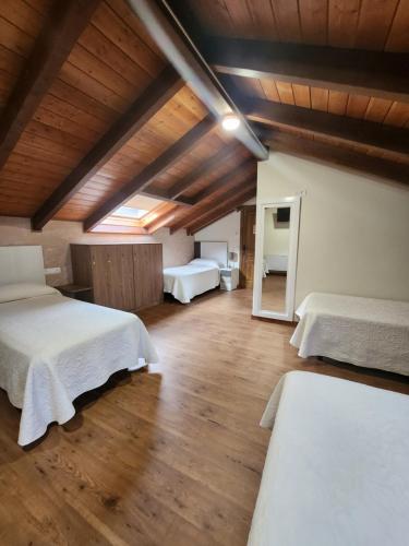 1 dormitorio con 2 camas y techo de madera en Saint James Way, en Cacabelos