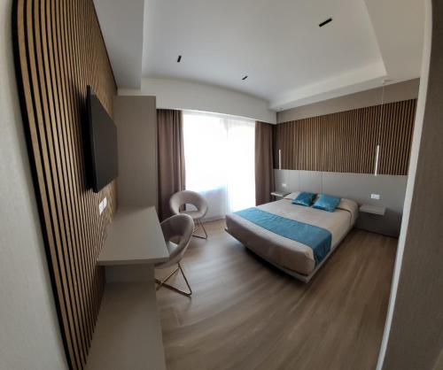 a bedroom with a bed and a desk and a television at Th Luxury Central in Catania