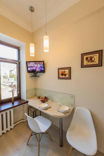 a room with a table and two chairs and a tv at Однокімнатні апартаменти на Майдані, дистанційне заселення 24х7 in Kyiv