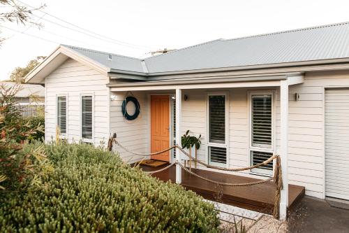 a small white house with a porch and a door at Romantic retreat in Mornington Peninsula Heartland in Dromana