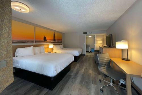 um quarto de hotel com duas camas e uma secretária em Days Inn and Suites by Wyndham Port Huron em Port Huron