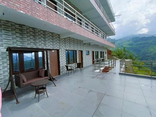 a balcony of a building with chairs and tables at Hotel Cloud Inn, Nainital in Rāmgarh