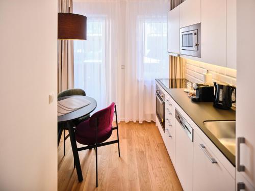 a kitchen with a table and a small table and chairs at MyFavorit Apartments - Spacious Apartments next to Puplic Transport U1 direct connection to Citycenter in Vienna