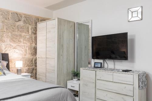 a bedroom with a bed and a dresser with a tv at Studio Toniko in Split