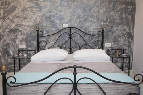 - une chambre avec un lit noir et des oreillers blancs dans l'établissement Village Anto Fira, à Fira