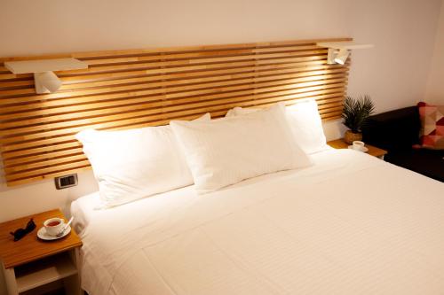 a bedroom with a large white bed with a wooden headboard at Reale House Rooms in Rome