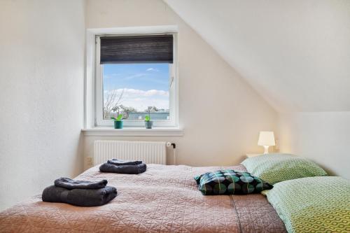a bedroom with two beds and a window at LOVELY TOP FLOOR Apart COPENHAGEN NEAR AIRPORT, METRO AND THE BEACH in Copenhagen