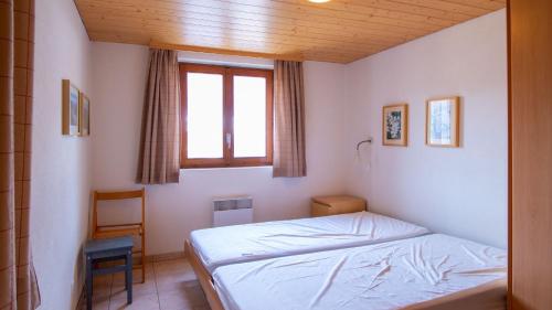 a small bedroom with a bed and a window at Stachelbeere UG in Fiesch