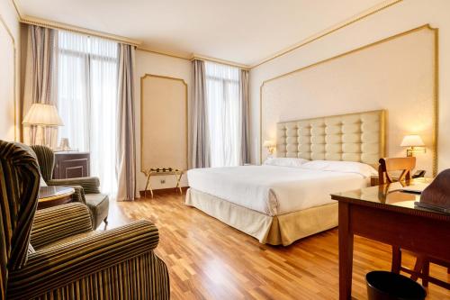 Großes Hotelzimmer mit einem Bett und einem Sofa in der Unterkunft Hotel Roger de Llúria in Barcelona