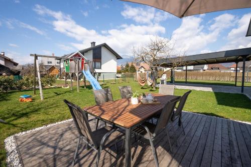 a wooden table with chairs and a playground at Home Away From Home in Radovljica