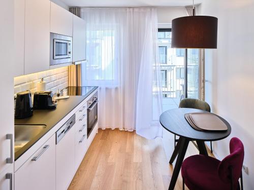 a kitchen with a table and a small table with a chair at MyFavorit Apartments - Spacious Apartments next to Puplic Transport U1 direct connection to Citycenter in Vienna