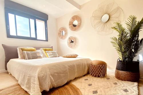 a bedroom with a bed and a plant and mirrors at Romy YourHostHelper in Saint-Cyr-sur-Mer
