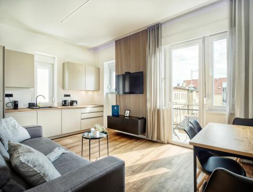 a living room with a couch and a kitchen at Cali & Rio Apartments by Irundo in Zagreb