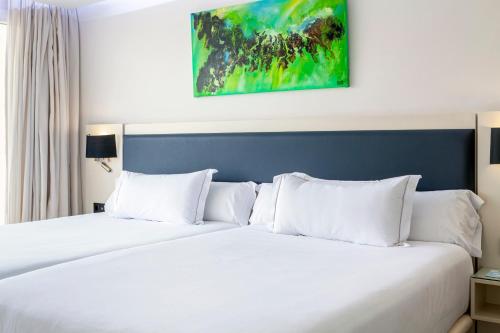 two beds with white pillows in a hotel room at Playasol in Roquetas de Mar