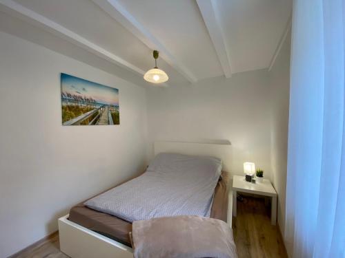 a small bedroom with a bed and a picture on the wall at Bene Vendégház in Szigliget