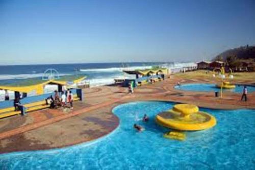 a large swimming pool next to a beach at 625 on Marine - 5 min from beach in Durban