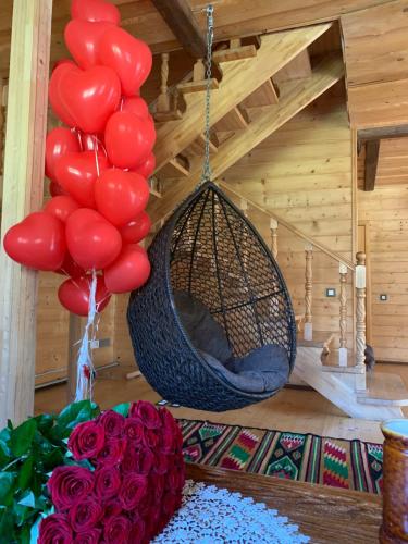 a room with red balloons and a hammock and roses at Guest House Pid Dubom Карпати Під Дубом in Skole