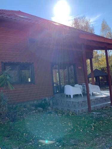 a house with a porch with two chairs and a table at Guest House Pid Dubom Карпати Під Дубом in Skole
