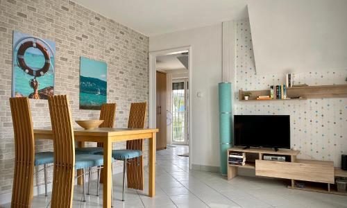 a dining room with a table and a television at Nefelejcs Apartmanház in Gyenesdiás