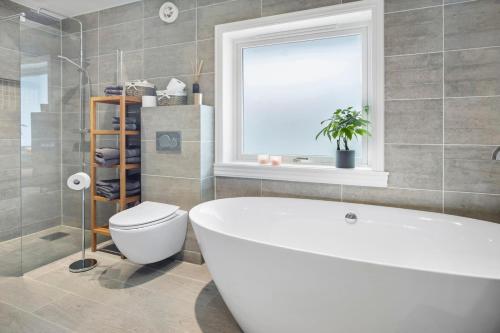 レーヌにあるHouse in the heart of Lofoten with spectacular viewの浴槽、トイレ、窓のあるバスルーム