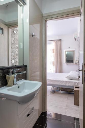 a bathroom with a sink and a bed at Beachfront Agia Marina Seafront Resort - Penthouse & Garden, Sleeps 9 in Stalos