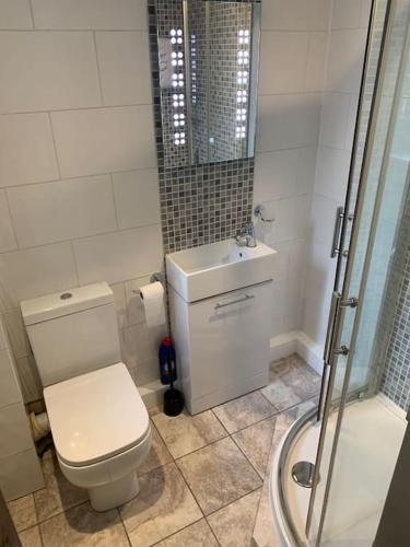 a bathroom with a toilet and a sink and a shower at Cozy Cottage 18th Century Seaside Escape Free parking in Weymouth
