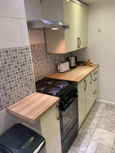 a kitchen with a stove and a counter top at Cozy Cottage 18th Century Seaside Escape Free parking in Weymouth