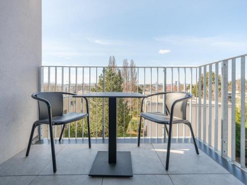 a table and two chairs on a balcony at MyFavorit Apartments - Spacious Apartments next to Puplic Transport U1 direct connection to Citycenter in Vienna