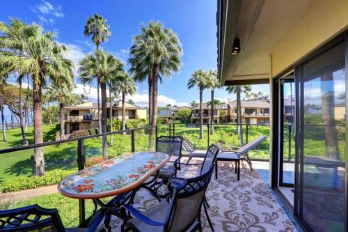 a balcony with a table and chairs and palm trees at WAILEA ELUA, #1204 condo in Wailea