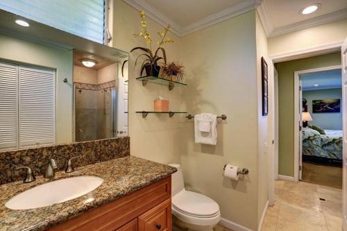 a bathroom with a sink and a toilet and a mirror at WAILEA ELUA, #1204 condo in Wailea