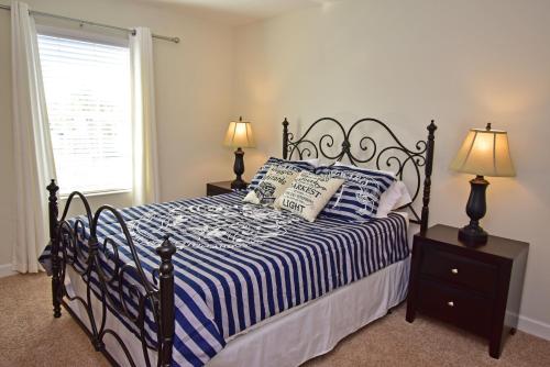um quarto com uma cama preta e branca com 2 candeeiros em 1586SW-Champions Retreat (S) em Davenport
