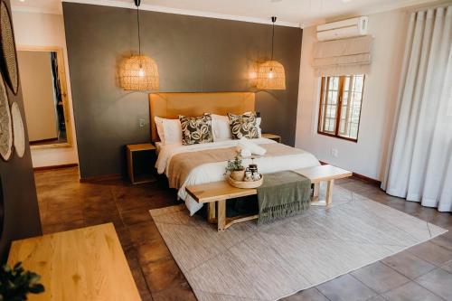 a bedroom with a large bed and a table at Linvale Country Lodge in Hazyview