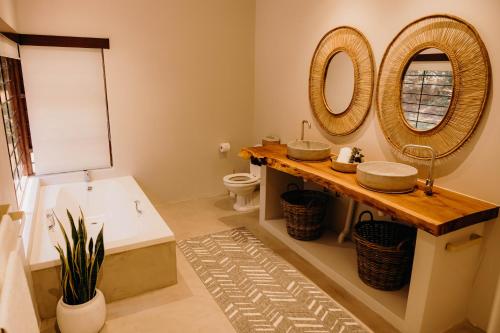 a bathroom with two sinks and a tub and a mirror at Linvale Country Lodge in Hazyview
