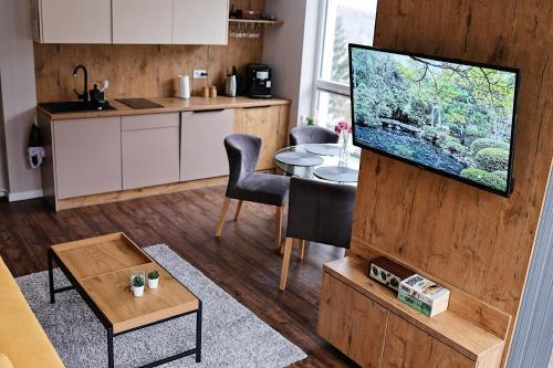 a living room with a television and a kitchen at Keller Apart - Kurort Kozubnik K25 in Porąbka