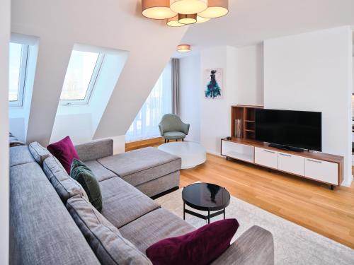 a living room with a couch and a flat screen tv at MyFavorit Apartments - Spacious Apartments next to Puplic Transport U1 direct connection to Citycenter in Vienna