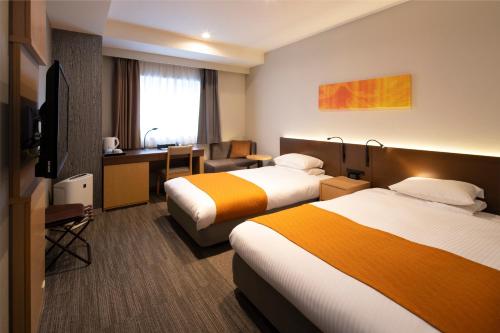 a hotel room with two beds and a desk at La'gent Stay Sapporo Odori Hokkaido in Sapporo