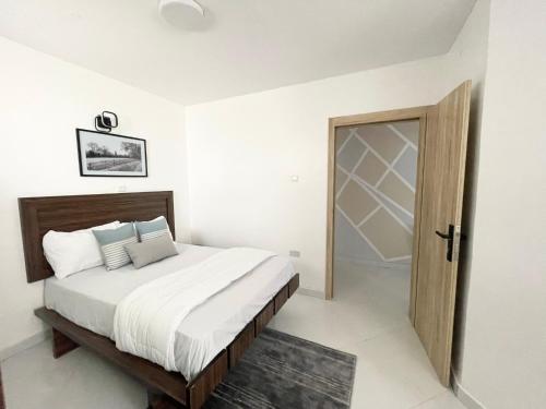 1 dormitorio con 1 cama y puerta de madera en Sigma Base Apartments en Lagos