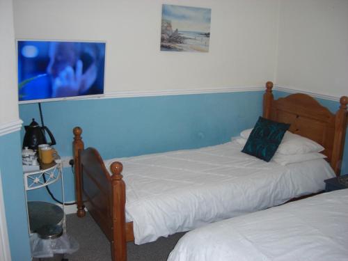 a bedroom with two beds and a picture on the wall at Lynebank House Hotel, Bed & Breakfast in Carlisle