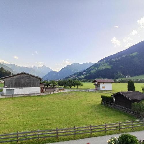 a large green pasture with mountains in the background at Ferienwohnung Zillertaler Alpenblick in Zell am Ziller