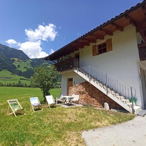 a house with two chairs and a table and a balcony at Ferienwohnung Zillertaler Alpenblick in Zell am Ziller