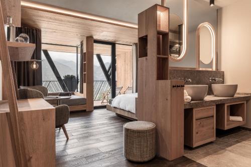 a bedroom with a bed and a bathroom with a sink at Santre dolomythic home in Bressanone