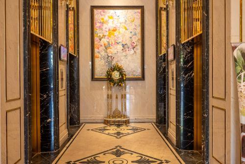 a hallway with a painting on the wall and a tile floor at Cozrum Homes - Sonata Residence in Ho Chi Minh City