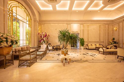 a large lobby with couches and tables and flowers at Cozrum Homes - Sonata Residence in Ho Chi Minh City