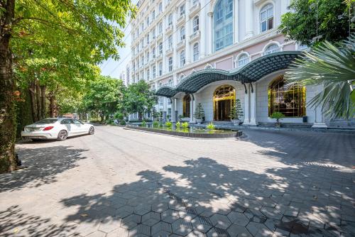 a white car parked in front of a building at Cozrum Homes - Sonata Residence in Ho Chi Minh City