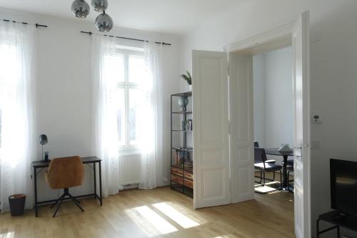 sala de estar con paredes blancas y ventana en Casa Nostra - Moderne lichtdurchflutete Wohnung am Augarten, en Viena