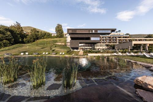 a building with a pond in front of a building at Santre dolomythic home in Bressanone
