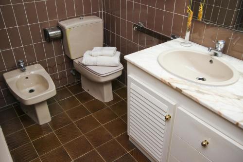 baño con aseo, lavabo y urinario en BAHIA II HomeStay by Turismar, en Salou