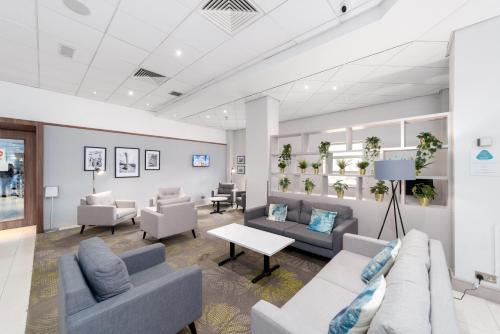 a waiting room with couches and chairs and a table at Novotel Southampton in Southampton